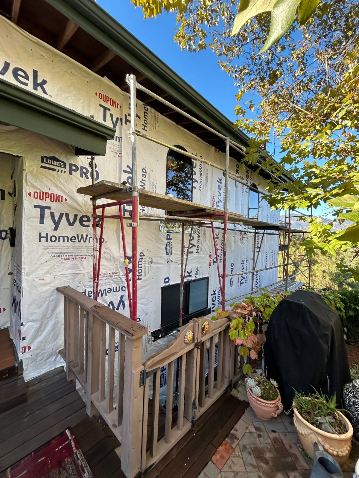 Weather-resistive barrier (house wrap) installed and taped around the arched entry window.
